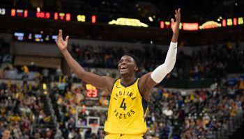 Indiana Pacers guard, #4, celebrates with his arms in the air after a big win