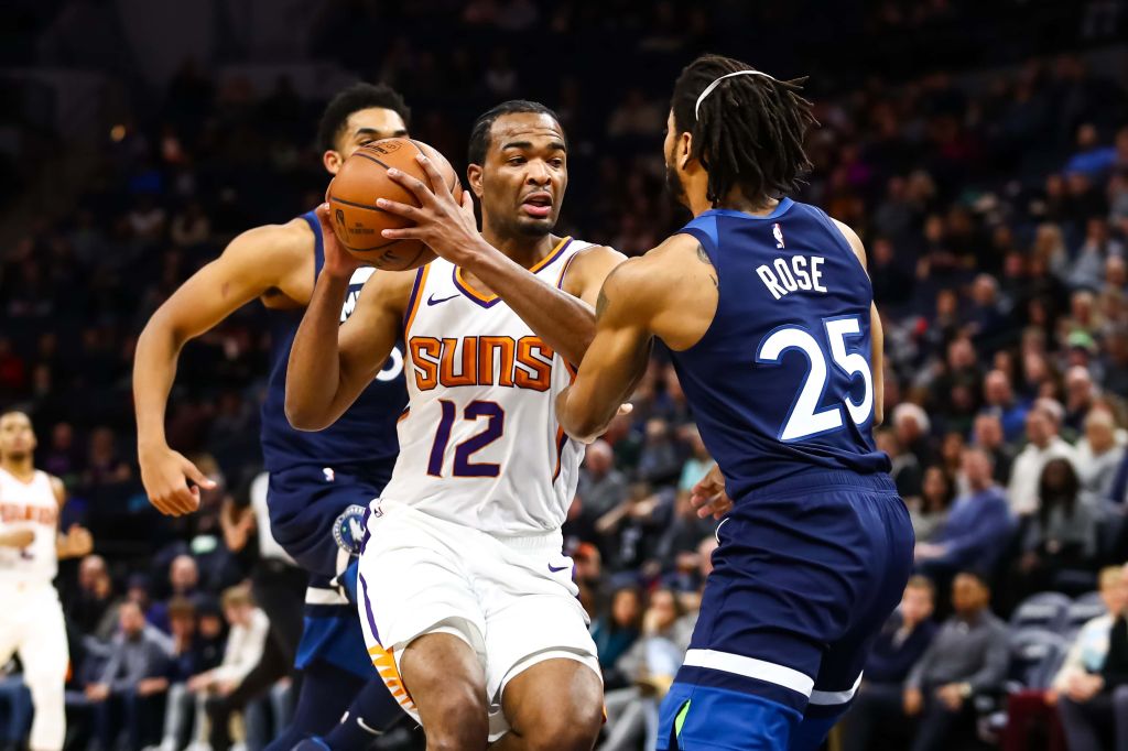T.J. Warren #12 of the Phoenix Suns drives to the net while Derrick Rose #25 of the Minnesota Timberwolves defends in the first