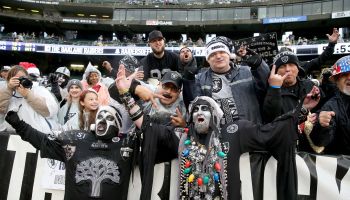 Oakland Raider fans in the "Black Hole" fan section cheer wildly before a game against the Denver Broncos