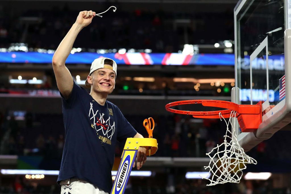 Kyle Guy waves to the crowd as he cuts down the net after winning the NCAA Championship