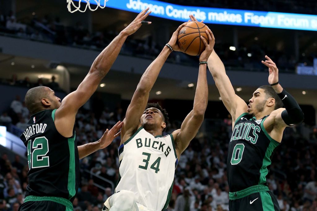 Giannis Antetokounmpo, #34 for the Bucks, goes up for a shot against Al Horfoed and Jayson Tatum of the Celtics