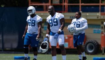 Colts defensive end Justin Houston stretches before an OTA session in 2019.