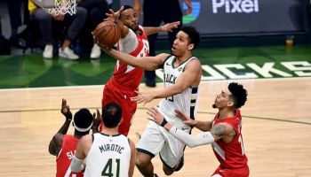 Malcolm Brogdon #13 of the Milwaukee Bucks attempts a shot while being guarded