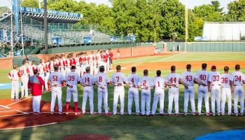 Both North Carolina State (left) and Indiana (right) line up for the National Anthem during the Lexington Regional College World