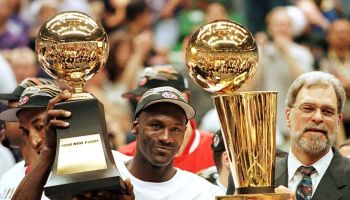 Michael Jordan and Phil Jackson hold up NBA Finals trophies
