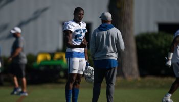 Colts cornerback Xavier Rhodes talks with his position coach.