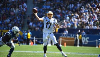 Philip Rivers rolls out of the pocket and throws down the field.