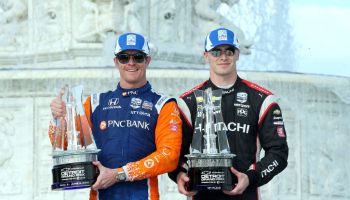 Scott Dixon and Josef Newgarden stand with trophies together on the podium in 2019