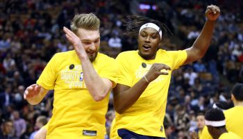 Domas Sabonis and Myles Turner greet each other and jump in the air in a Pacers game last season