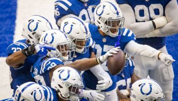 The Indianapolis Colts defense huddles together looking at a camera and celebrates a touchdown in their Week 3 game versus the New York Jets