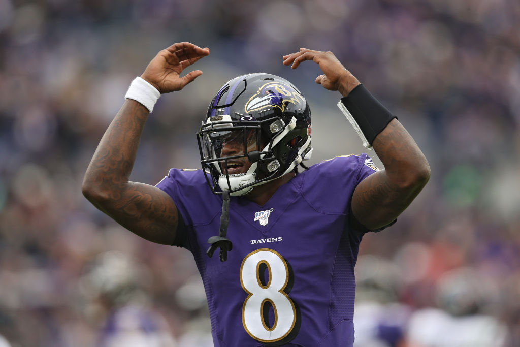 Ravens QB-Lamar Jackson raises his hands to the sky.
