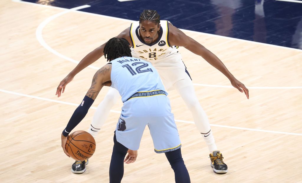Pacers forward Justin Holiday stretches out his arms to guard Grizzlies star Ja Morant