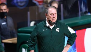 Tom Izzo watches his Michigan State team on the sideline with one hand on his hip