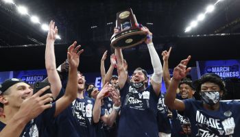 The Gonzaga Bulldogs huddle together and lift their regional trophy as they win in the Elite 8 against USC