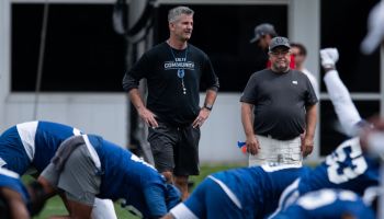 Frank Reich talks with his team before practice.