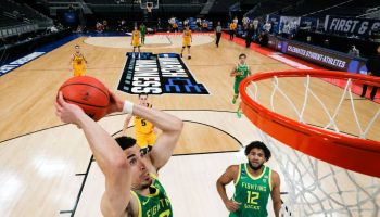During March Madness, Chris Duarte goes up and slams a dunk with his Oregon teammates and opponents watch from behind