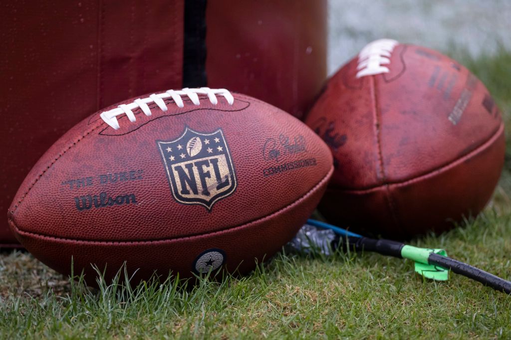 NFL Footballs leaning up against the field goal post