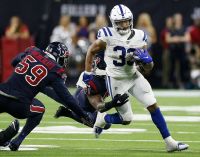 Whitney Mercilus goes in to tackle a Colts player rushing the ball with a Texans teammate