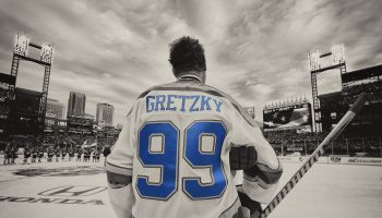 Wayne Gretzky prepares to play in an NHL outdoor alumni game looking up at the stands in a baseball ballpark
