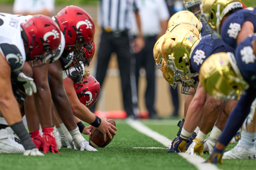 Cincinnati and Notre Dame lineup in the trenches with offensive and defensive lineman on the ball