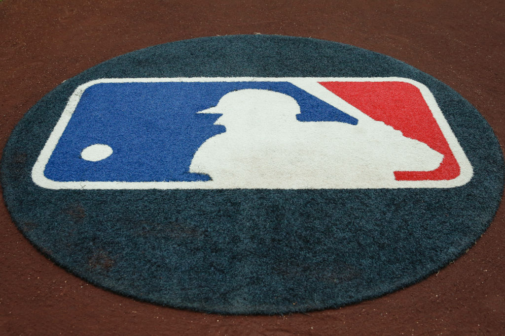 An on-deck circle on a baseball diamond with a cover that has the MLB logo printed on it