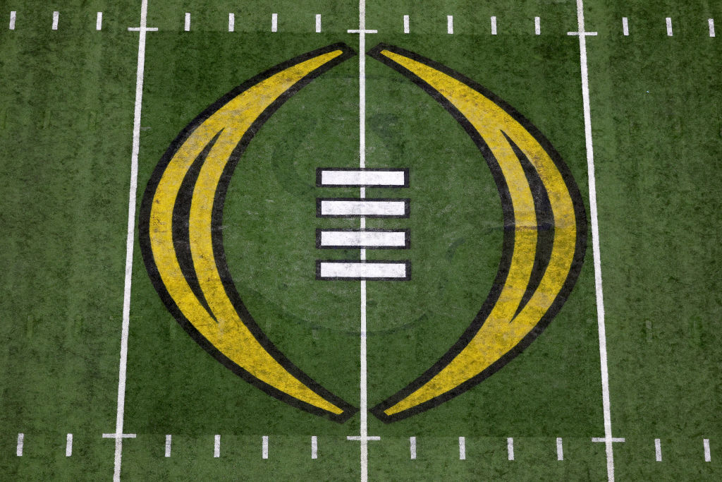 A close up shot of midfield and the College Football Playoff logo in the middle of Lucas Oil Stadium