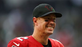 Former Falcons QB-Matt Ryan smiles while looking on the field.