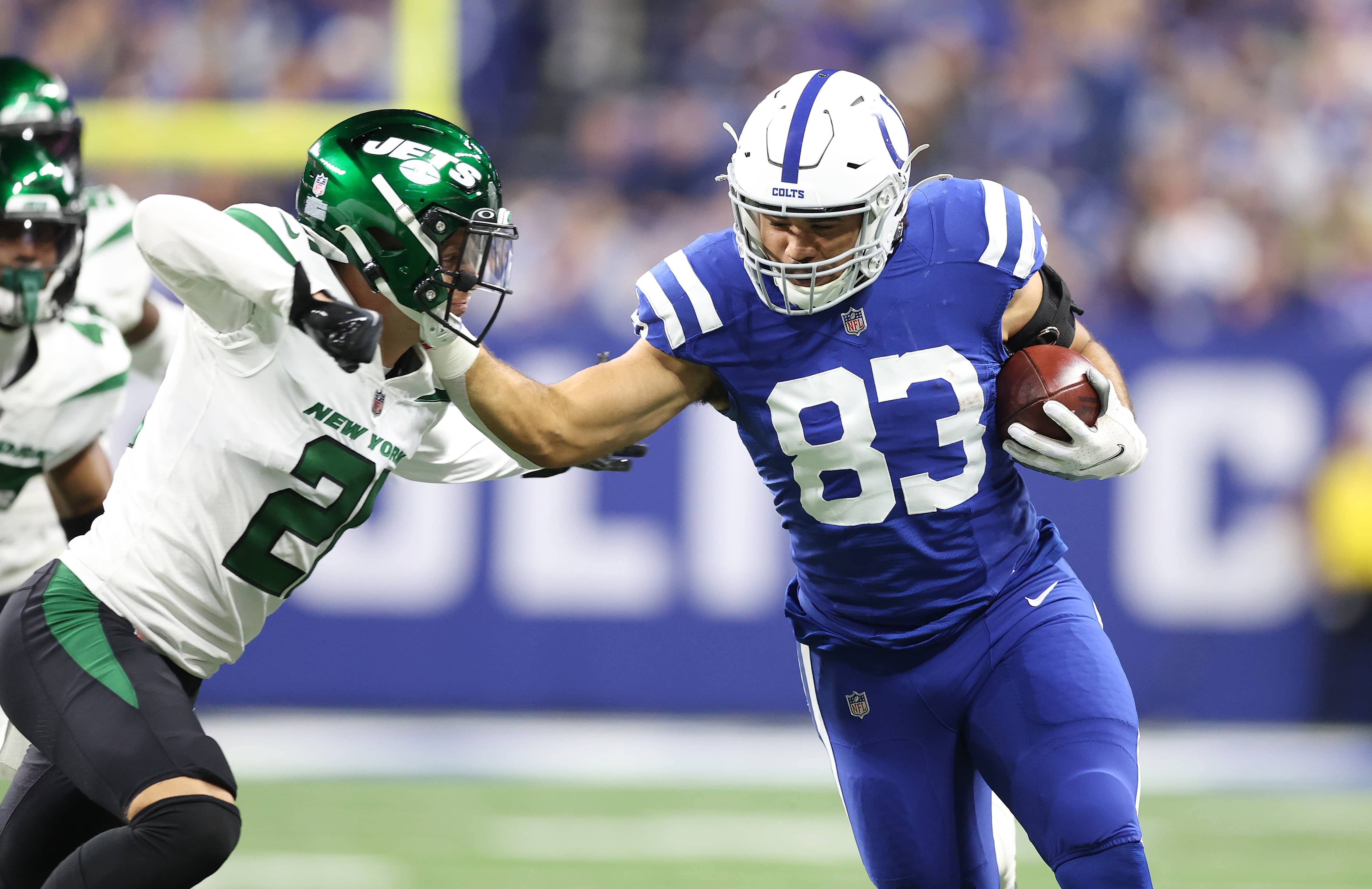 Kylen Granson throws a stiff arm against a NY Jets defender