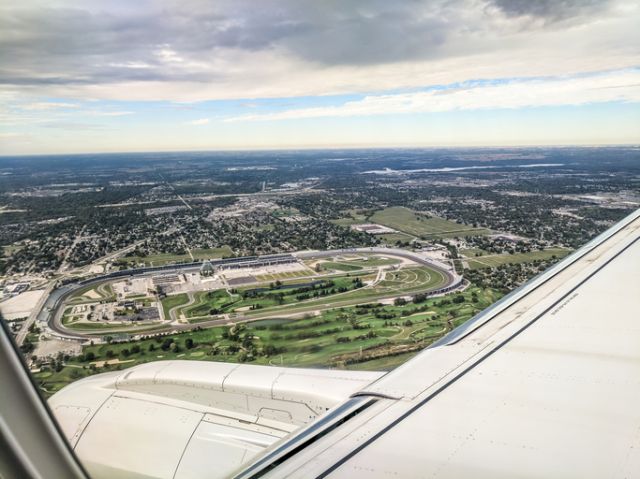 Aerial view of Indianapolis Motor Speedway with airplane wing