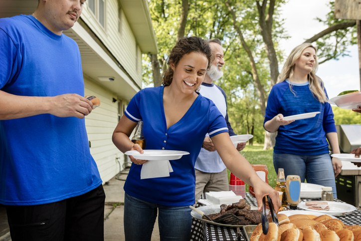 Friends drinking and eating at a tailgate party