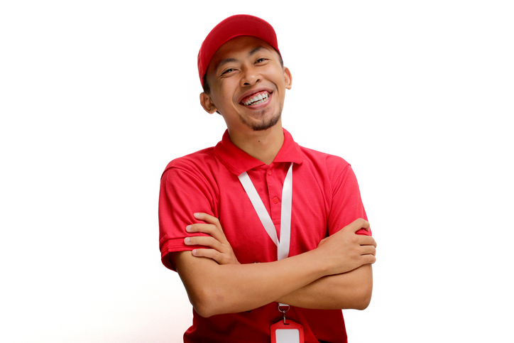 Confident Asian Professional Delivery Man in Red Uniform with Crossed Arms