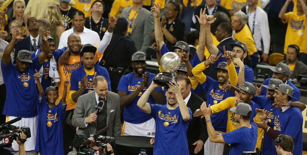 Golden State Warrior's Klay Thompson holds the Western Conference trophy as his teammates celebrate their win over Oklahoma City Thunder in Game 7 of the NBA Western Conference finals at Oracle Arena in Oakland, Calif., on Monday, May 30, 2016. (Aric Cra
