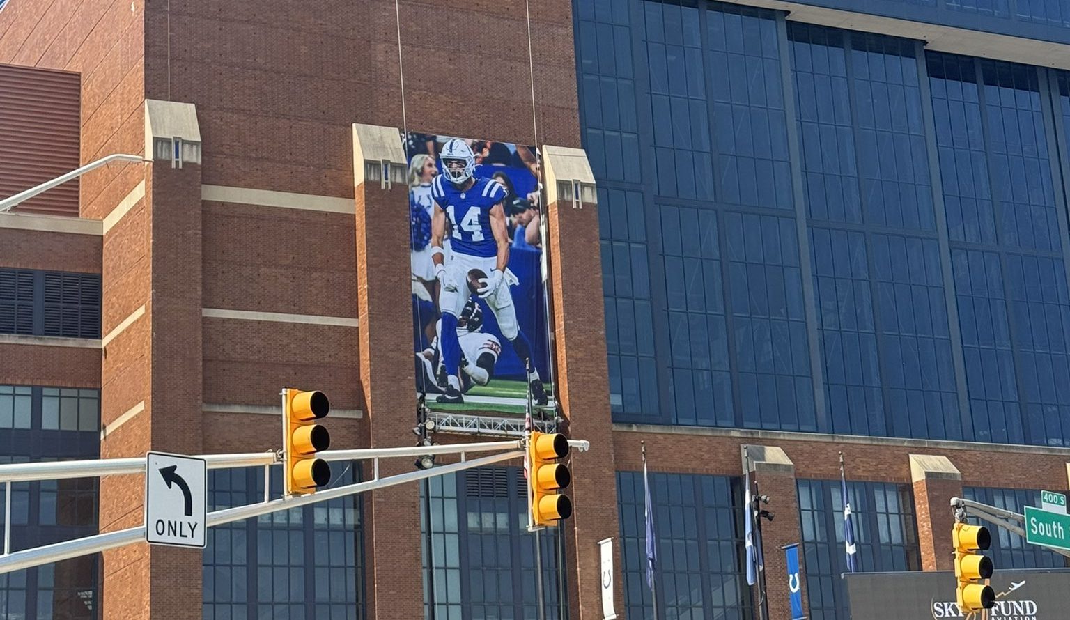 A large brick building with the "Lucas Stadium" sign, featuring a large image of a football player in a blue uniform on the side.
