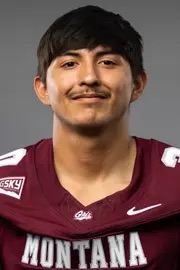 A smiling young man wearing a maroon jersey with "MONTANA" printed on it.