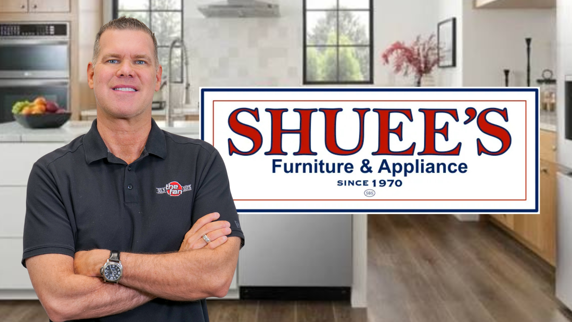 A smiling man with short gray hair wearing a dark polo shirt stands in front of a kitchen appliance showroom with a large "Shuee's Furniture & Appliance" sign.